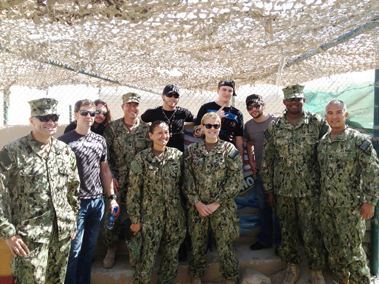 Brantley Gilbert and band pose with military members on a base in Kuwait.