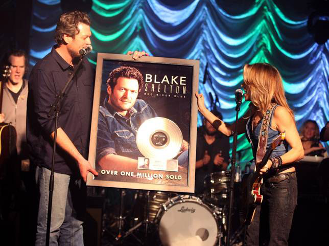 Sheryl Crow (R) presents Blake Shelton  with a plaque 